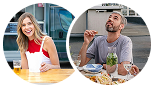 Zwei Personen sitzen im Freien an getrennten Tischen und genießen Essen und Getränke. Die Frau lächelt, während der Mann beim Essen nach oben schaut.