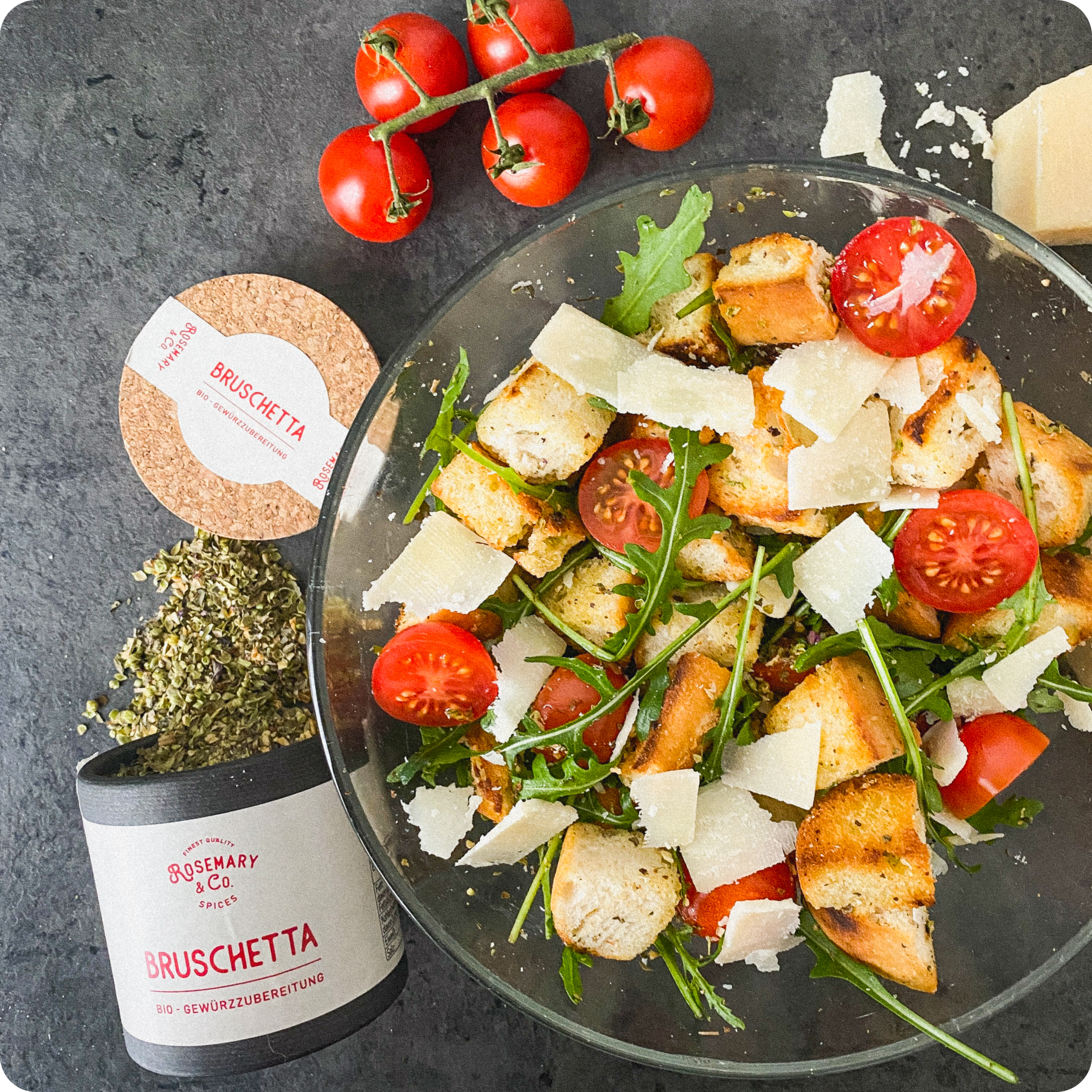 Salat mit Brotwürfeln, Cherrytomaten, Rucola, Käse und Dose Rosemary & Co. Gewürze Bruschetta Bio
