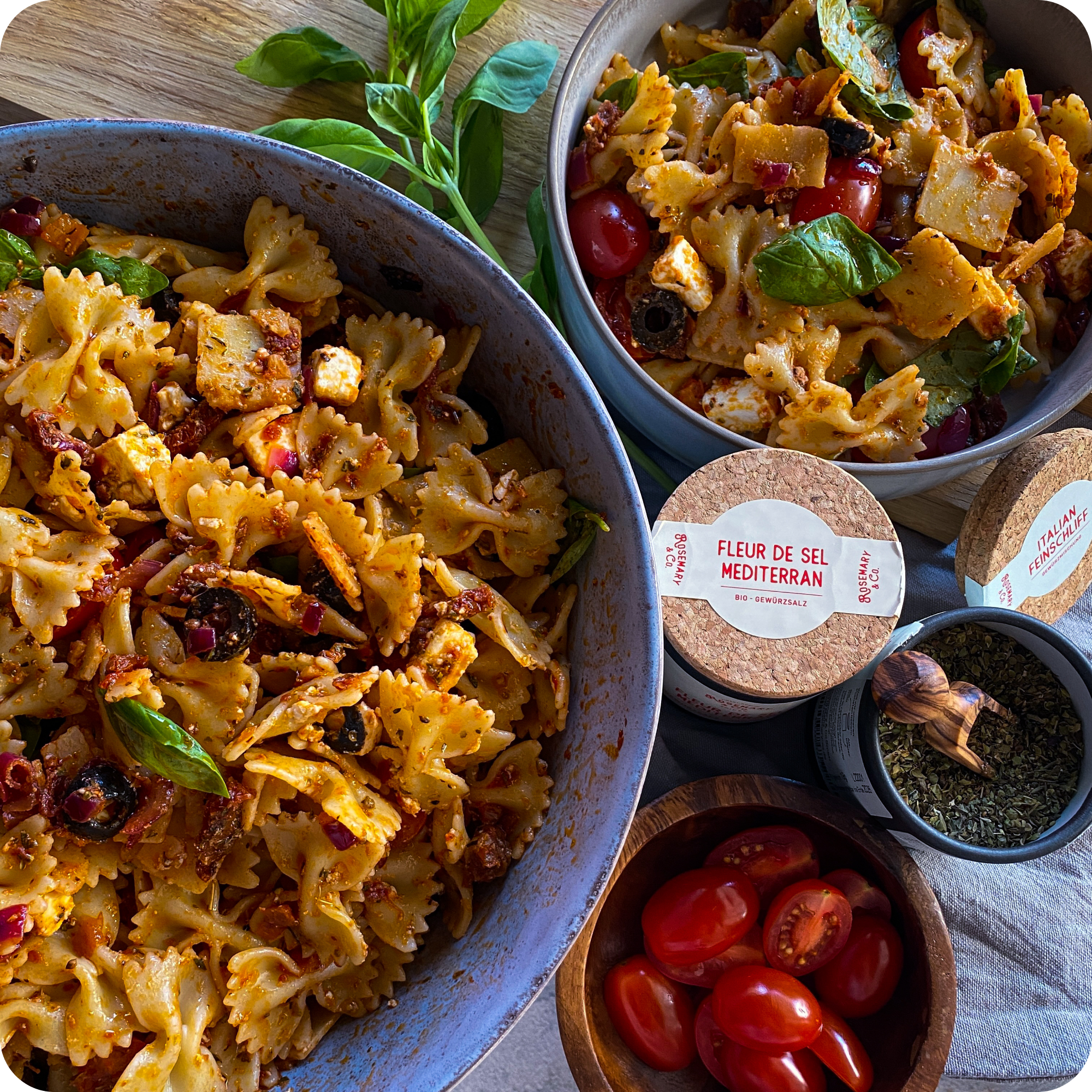 Dosis Rosemary & Co Italian Feinschliff neben Schleifen-Nudeln, Oliven, Käse, Salat, Basilikum, Gewürzen und Tomaten
