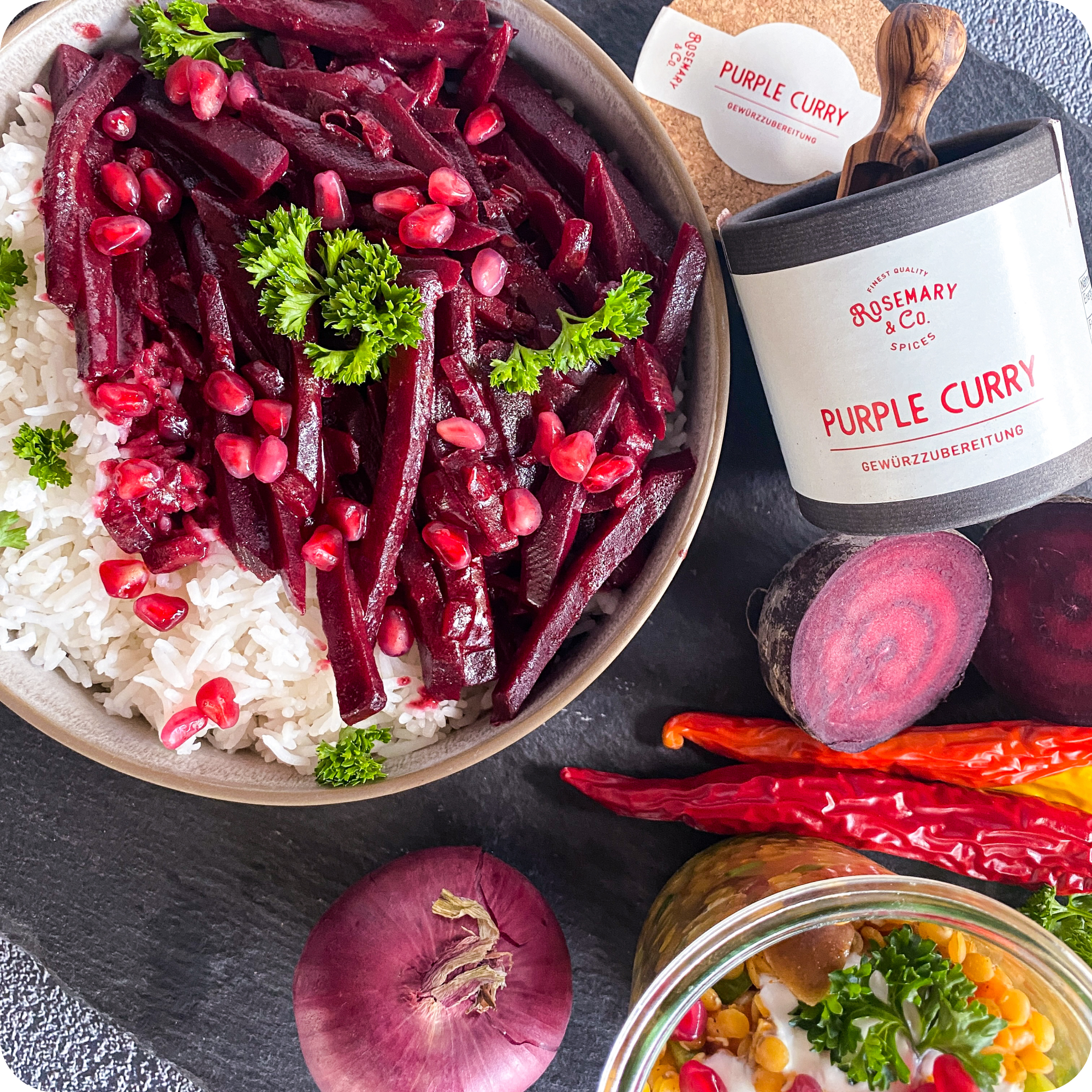 Schale Reis mit Rote Bete und Granatapfel neben Dose Rosemary & Co. Gewürze Purple Curry und frischem Gemüse